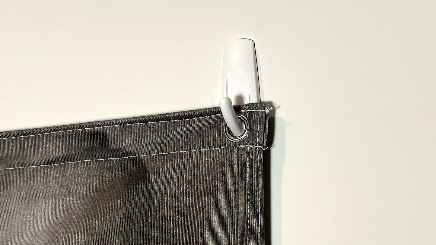 Close-up of the metal grommet and Command hook holding the QuickStudio fabric backdrop