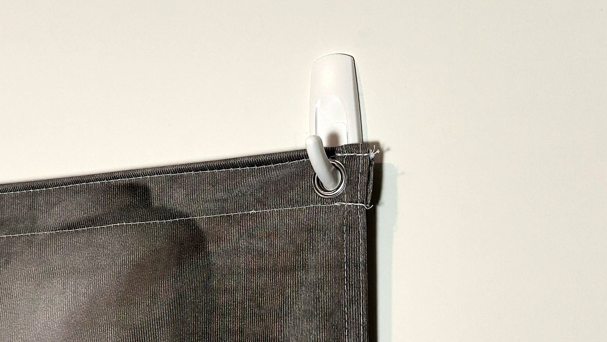 Close-up of the metal grommet and Command hook holding the QuickStudio fabric backdrop